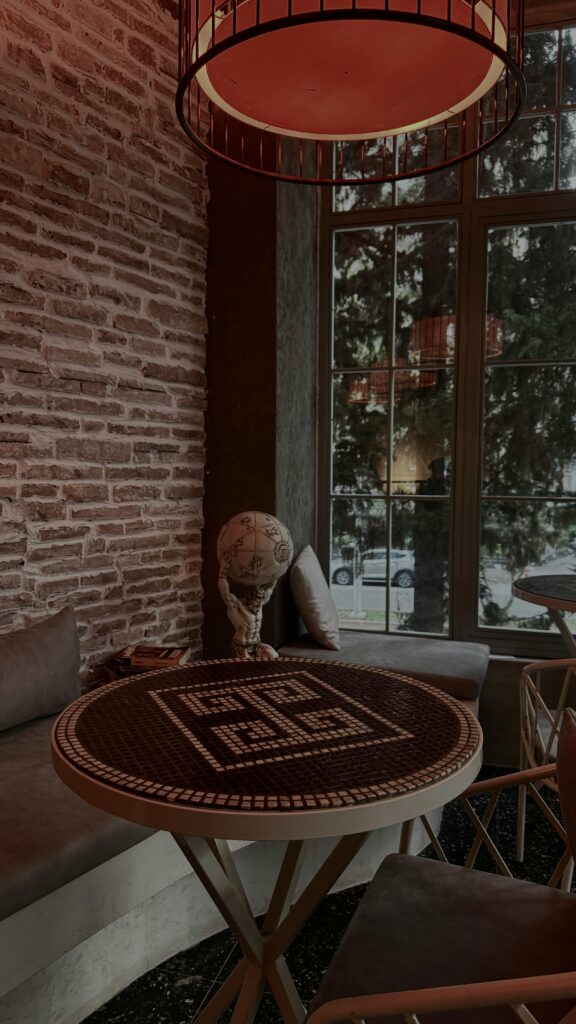 Inviting cafe corner with brick walls and ornate table under warm lighting.