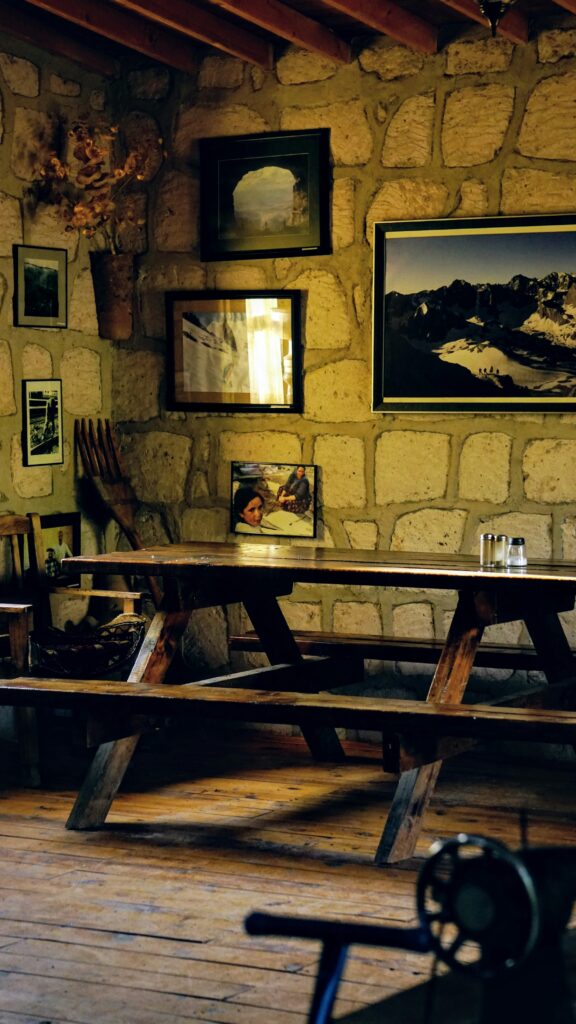 Warm and inviting rustic cafe interior with stone walls and wooden tables.